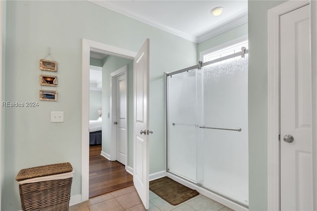 bathroom with tile patterned flooring, crown molding, and walk in shower