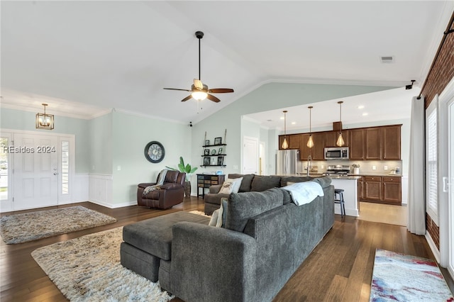 living room featuring dark wood-type flooring, ornamental molding, sink, and vaulted ceiling