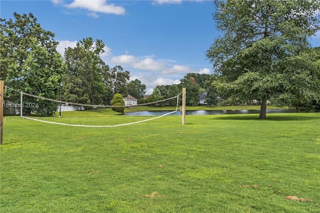 view of community with a water view, a yard, and volleyball court