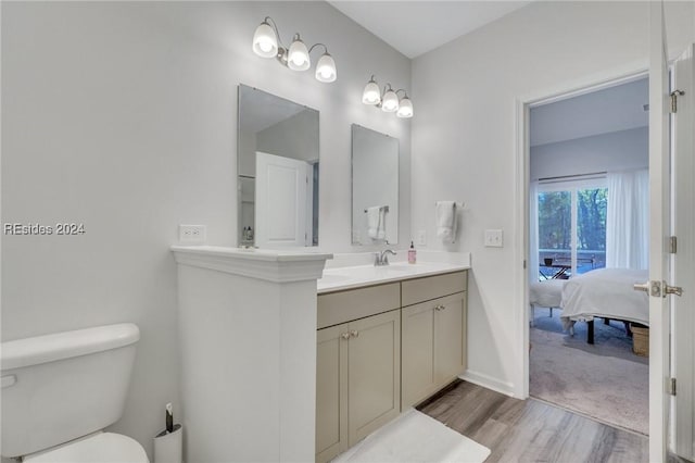 bathroom with hardwood / wood-style flooring, vanity, and toilet