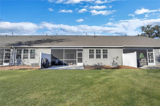 back of house featuring a patio, a sunroom, a yard, and central AC