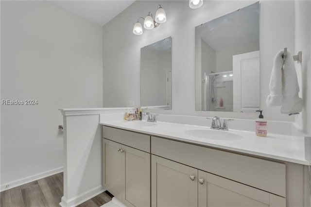 bathroom with hardwood / wood-style flooring, vanity, and an enclosed shower