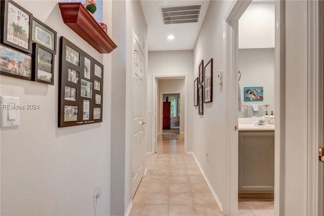 hall featuring sink and light tile patterned floors