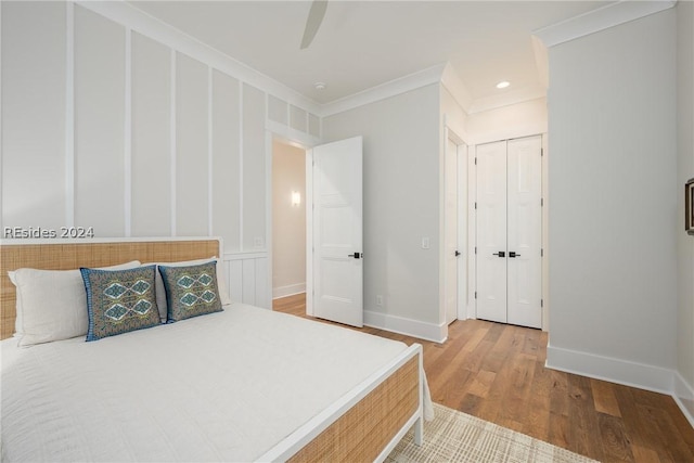 bedroom with hardwood / wood-style flooring, ceiling fan, and ornamental molding