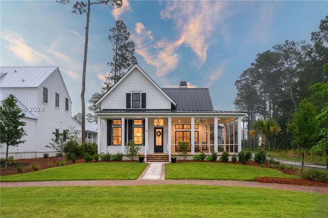 modern inspired farmhouse with a front lawn and a porch