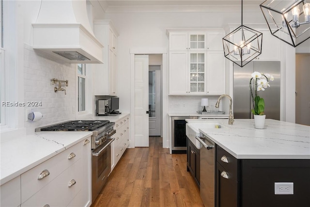 kitchen featuring high quality appliances, premium range hood, and white cabinets