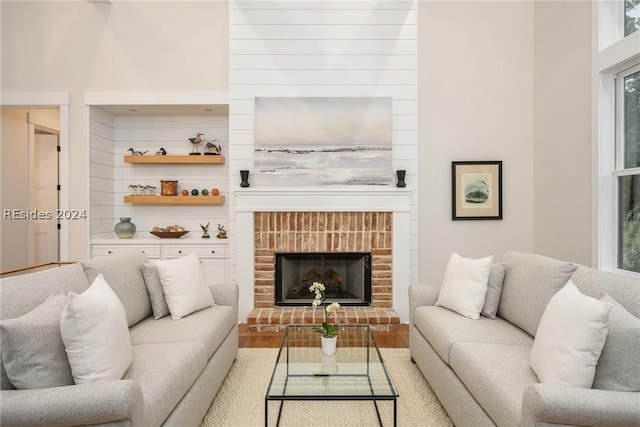 living room featuring hardwood / wood-style flooring, a brick fireplace, and a wealth of natural light