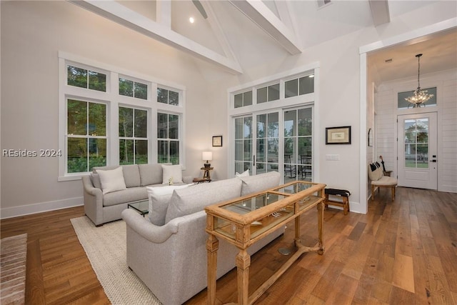 living room featuring beamed ceiling, high vaulted ceiling, hardwood / wood-style floors, and a notable chandelier