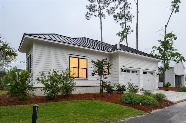 view of front of property featuring a garage and a front lawn