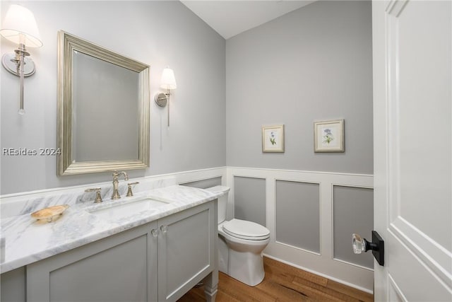 bathroom with vanity, hardwood / wood-style floors, and toilet