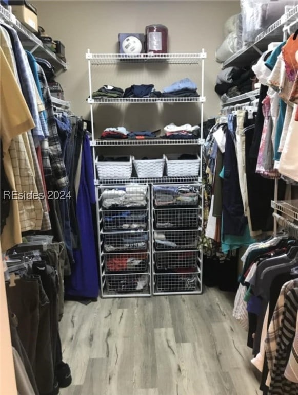 spacious closet with light hardwood / wood-style flooring