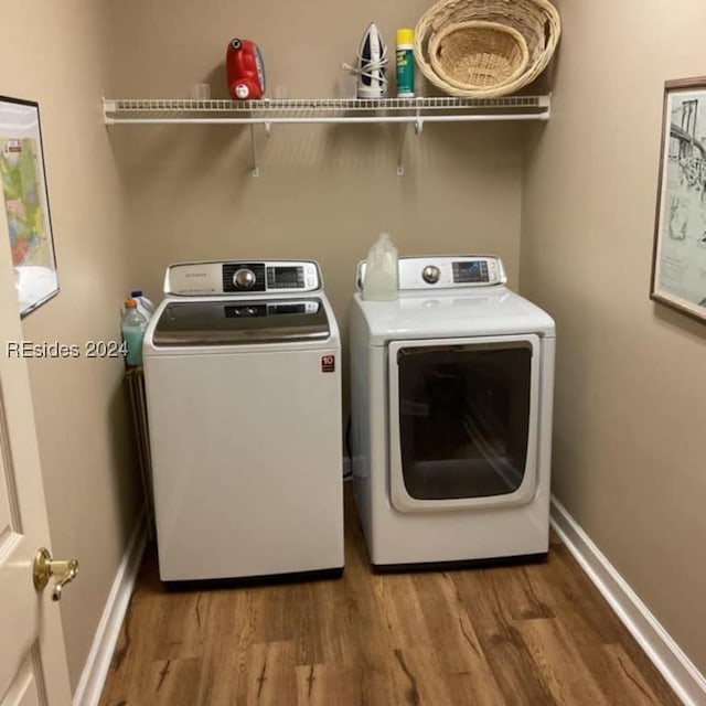 clothes washing area with hardwood / wood-style flooring and washer and dryer