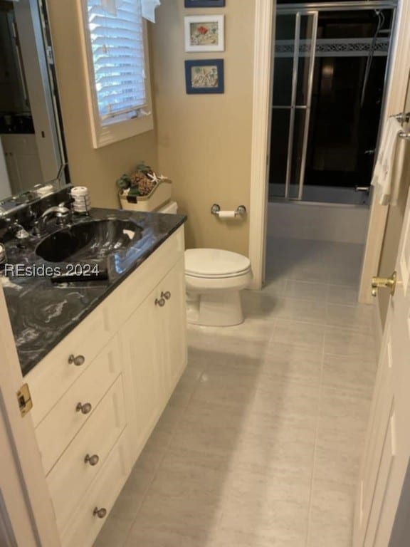 bathroom with vanity, a shower with shower door, and toilet