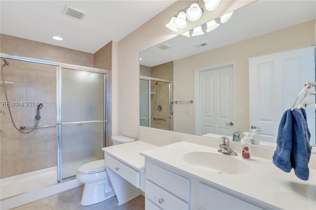 bathroom featuring vanity, tile patterned flooring, toilet, and walk in shower