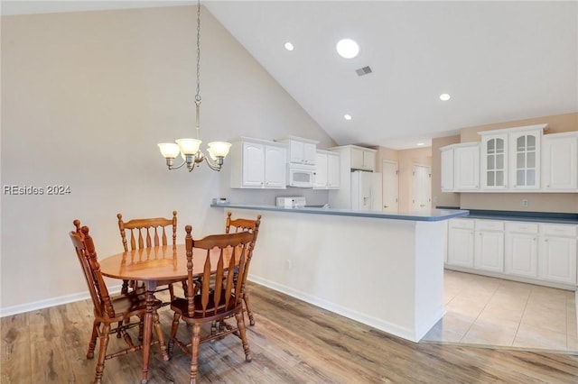 interior space with a chandelier, light hardwood / wood-style floors, and high vaulted ceiling