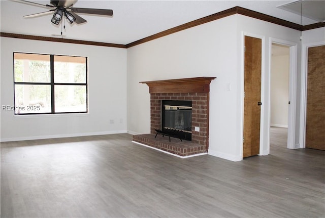 unfurnished living room featuring dark wood-type flooring, ceiling fan, ornamental molding, and a brick fireplace