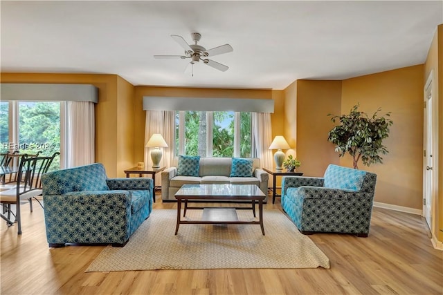 living room with ceiling fan, wood-type flooring, and plenty of natural light