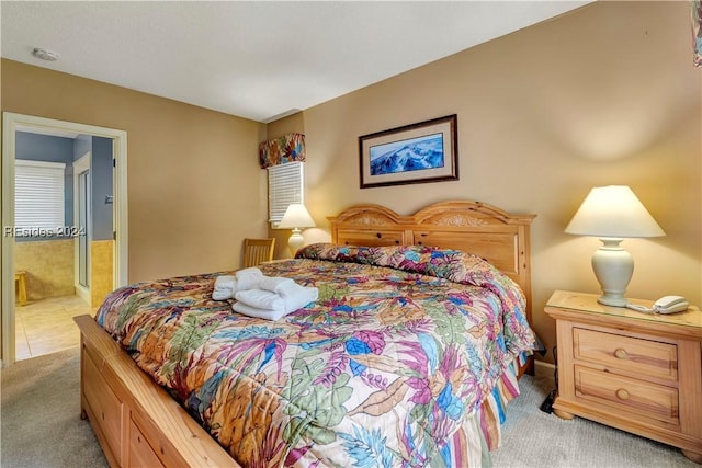 bedroom with light carpet and ensuite bathroom