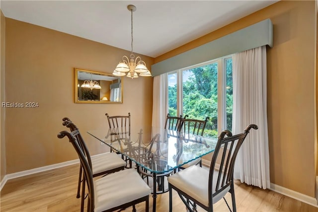 dining area with a notable chandelier and light hardwood / wood-style flooring