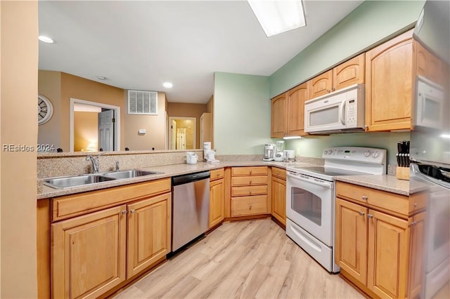 kitchen with sink, white appliances, kitchen peninsula, light brown cabinets, and light wood-type flooring