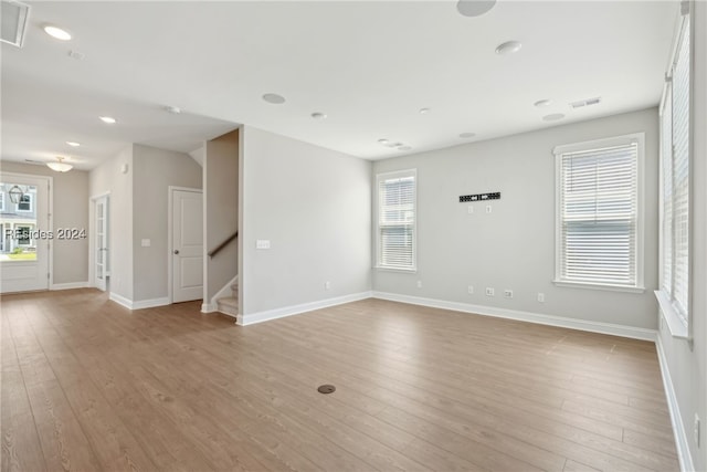 unfurnished room featuring a wealth of natural light and light hardwood / wood-style floors