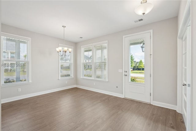 foyer entrance featuring wood-type flooring and a chandelier