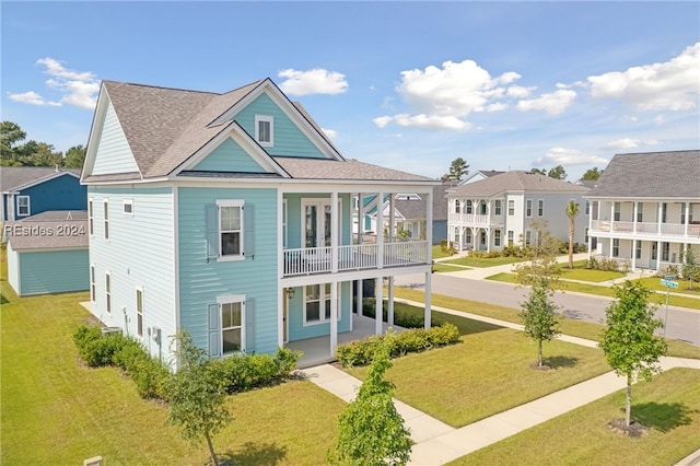 view of front facade featuring a front yard, a balcony, and a porch