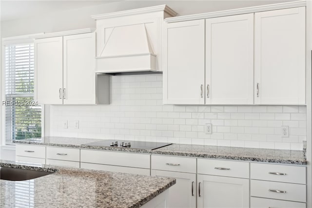 kitchen with custom range hood, white cabinets, and decorative backsplash