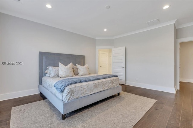 bedroom with dark hardwood / wood-style flooring and crown molding