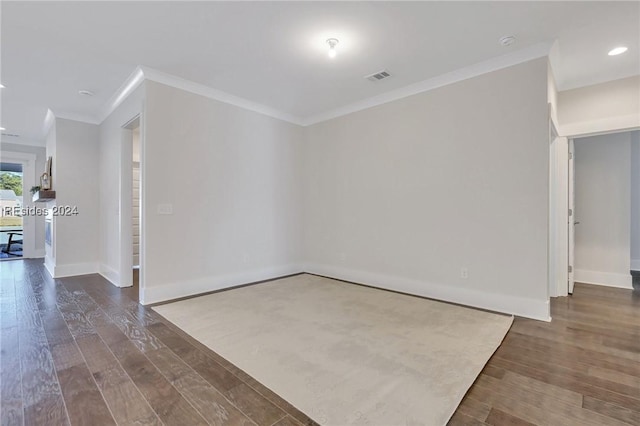 spare room with dark hardwood / wood-style flooring and crown molding