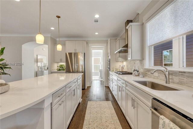 kitchen with pendant lighting, sink, white cabinetry, and appliances with stainless steel finishes