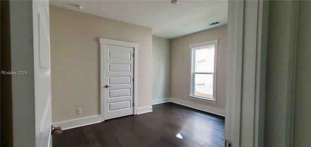 unfurnished room with dark wood-type flooring