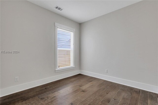 unfurnished room with dark wood-type flooring