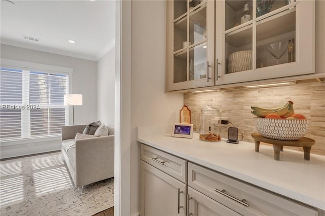 bar with hardwood / wood-style flooring, ornamental molding, and decorative backsplash