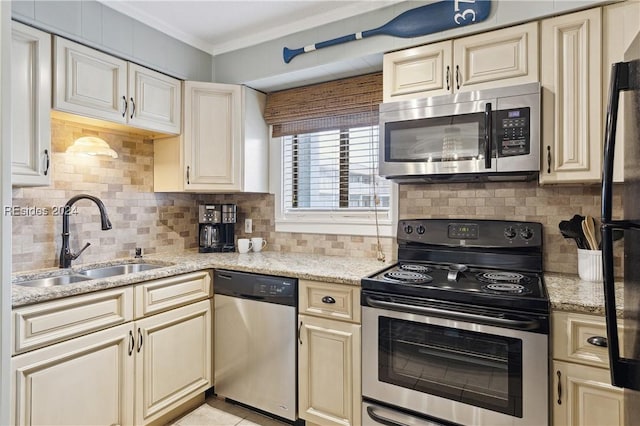 kitchen with tasteful backsplash, cream cabinets, stainless steel appliances, and sink