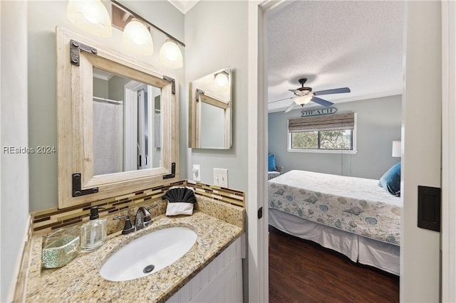 bathroom with a textured ceiling, vanity, hardwood / wood-style flooring, ceiling fan, and decorative backsplash