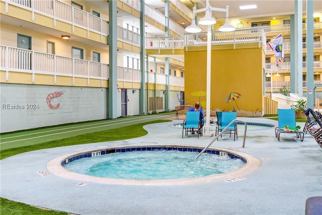 view of swimming pool featuring a hot tub and a patio area