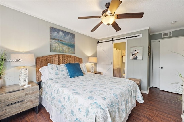 bedroom featuring dark hardwood / wood-style flooring, ornamental molding, a barn door, and ceiling fan