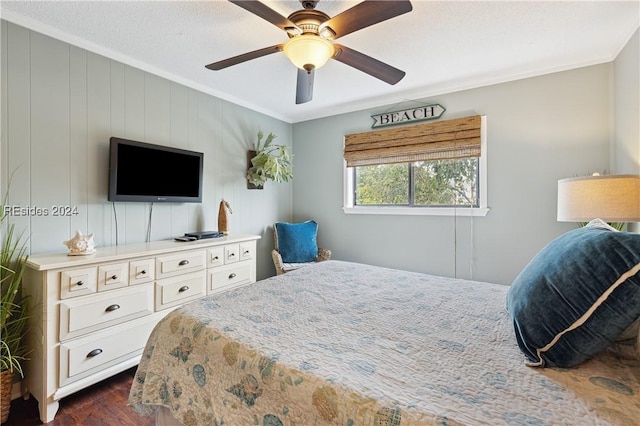 bedroom with ornamental molding, dark wood-type flooring, ceiling fan, and wood walls