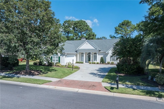 view of front of property with a garage and a front lawn