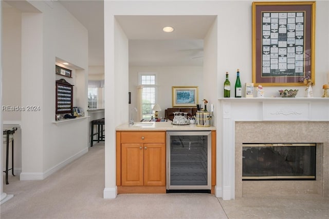 bar featuring wine cooler, sink, and light colored carpet