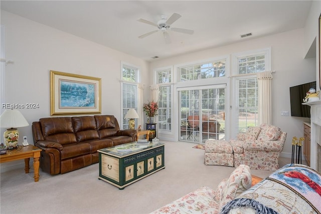 living room featuring ceiling fan, carpet, and a fireplace