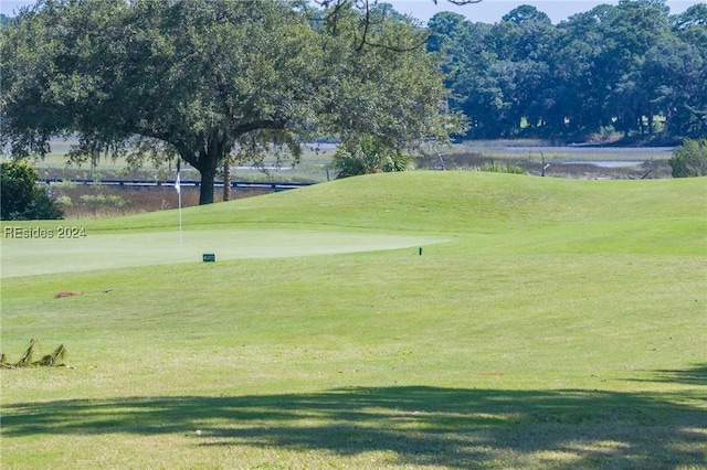 surrounding community featuring a water view and a lawn