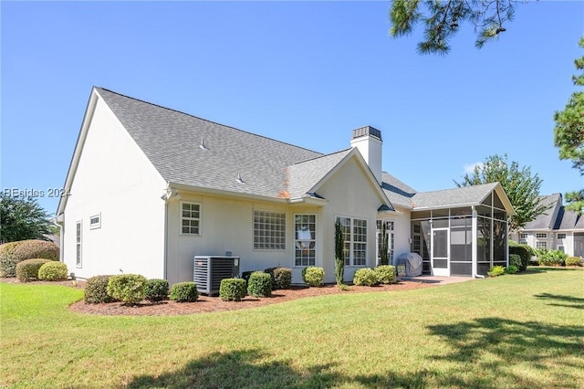 rear view of house featuring a sunroom, a yard, and cooling unit