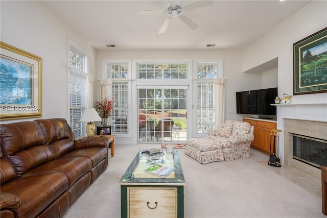 carpeted living room with ceiling fan and a high end fireplace