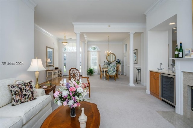 living room with wine cooler, light colored carpet, ornamental molding, and ornate columns