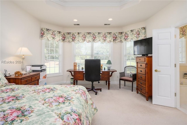 carpeted bedroom with ornamental molding and a tray ceiling