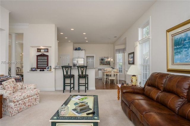 living room featuring a wealth of natural light, light colored carpet, and decorative columns