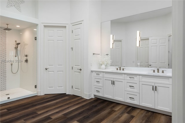 bathroom with hardwood / wood-style flooring, vanity, and a shower