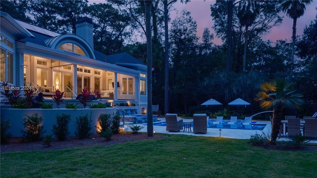 yard at dusk featuring a patio area